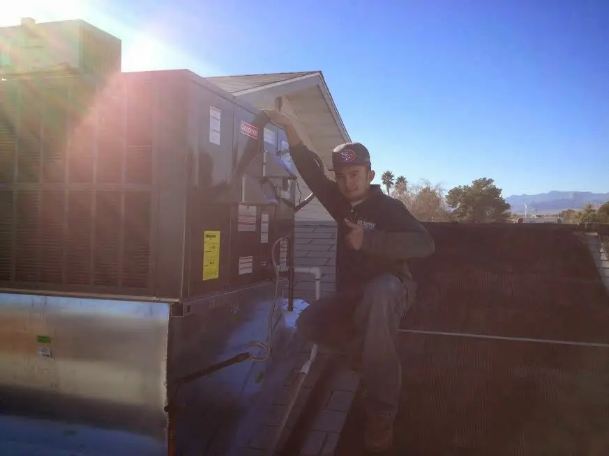 HVAC technician performing Heat Pump Repair on a rooftop unit in Erwin